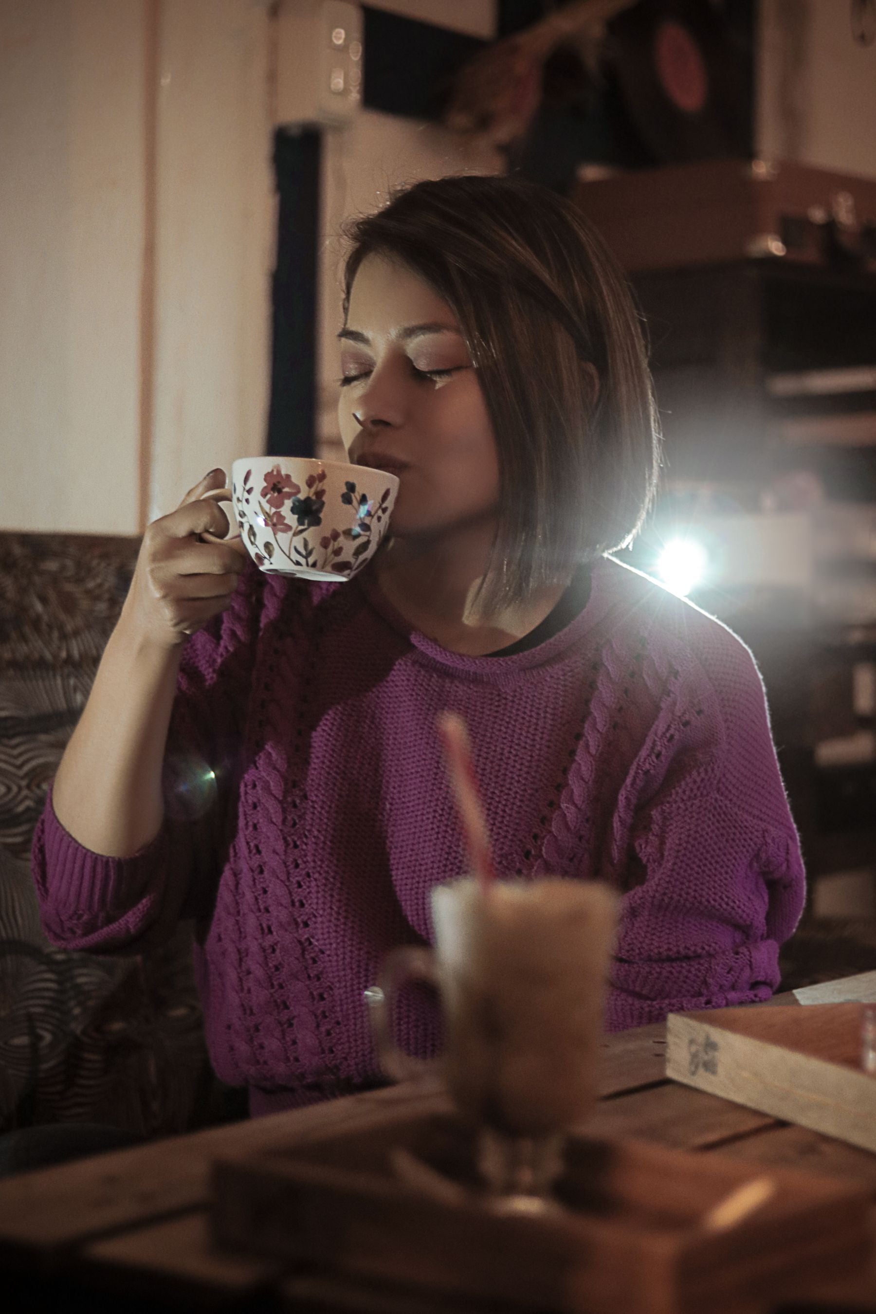 Kvinde i striksweater med kaffe